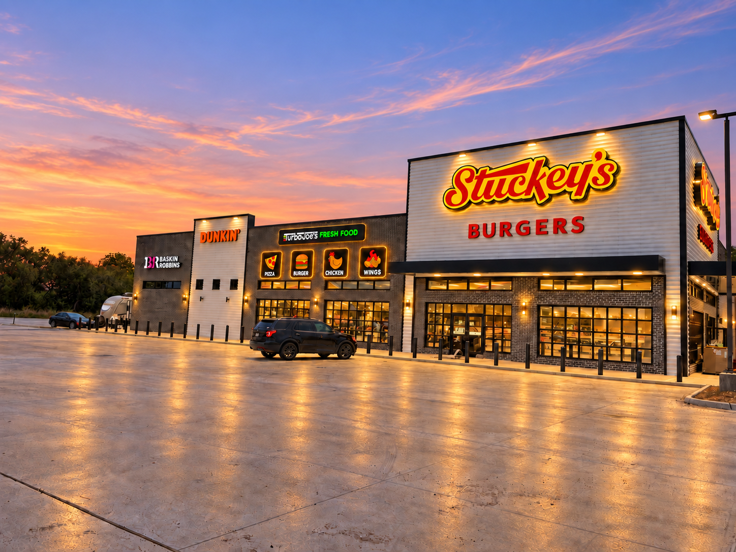 Angled Stuckey’s storefront with illuminated Turbo Joe’s signage beneath a rose and blue sunset